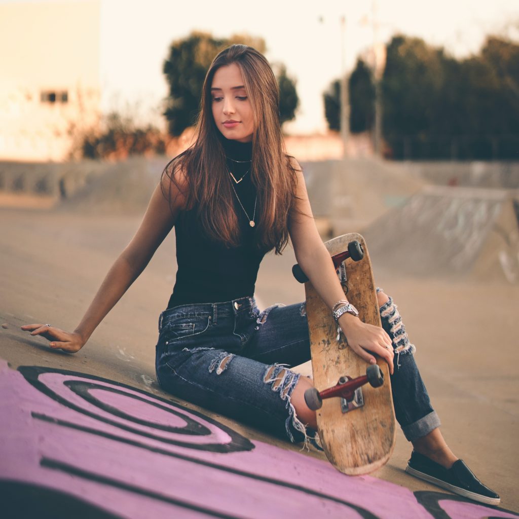 woman holding brown skateboard